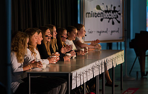 Präsentation des Konzepts für Mehrwegbecher-Edition: fair, regional, saisonal steht auf den Bechern. Gruppenbild zum Cupsong.