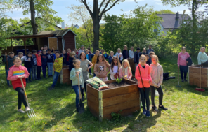 Die Grundschüler*innen der Schule Arbergen posieren neben Hochbeeten im Schulgarten