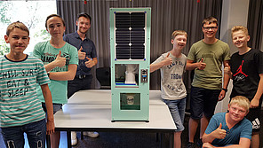 Schüler mit Prototyp-Ausgabeautomat für Becher.