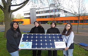Schüler*innen mit Solar-Panel vor Schulgebäude in Gladbeck.